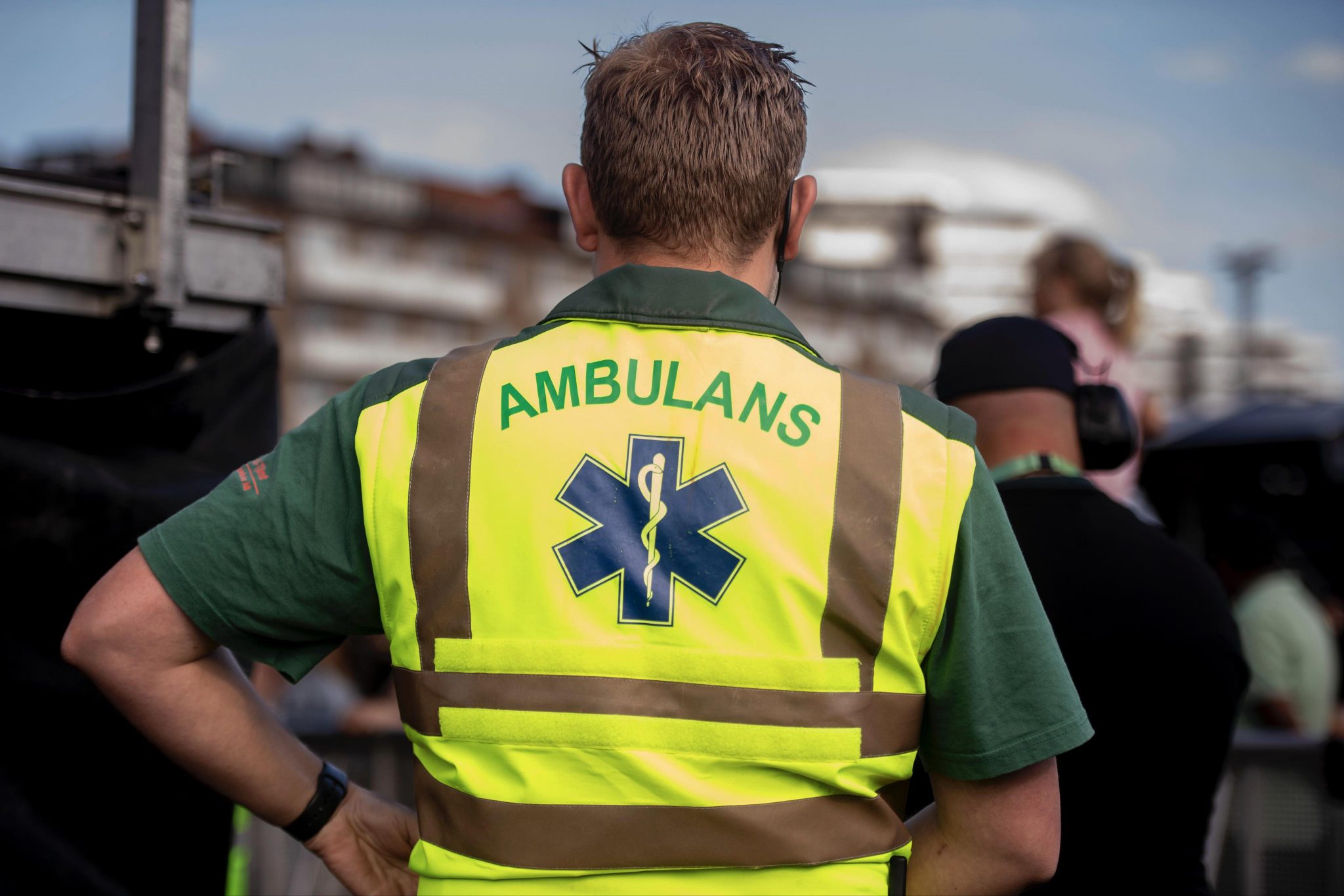 Ambulanspersonal i varselväst märkt Ambulans med livets stjärna, på plats vid ett evenemang